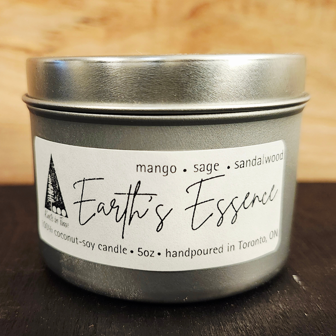 Candle tin labeled 'Earth's Essence' with a wooden background