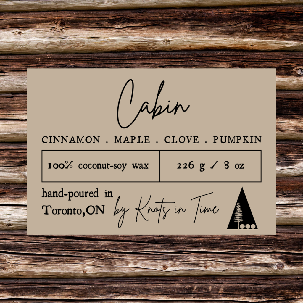 Label for candles with 'Cabin' scent on a wooden background