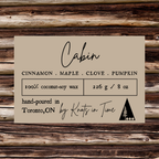 Label for candles with 'Cabin' scent on a wooden background