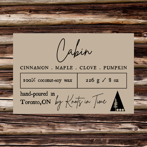 Label for candles with 'Cabin' scent on a wooden background