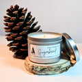 Gingerbread scented candle in a tin with a pine cone on a light background