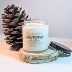 Gingerbread scented candle with a pine cone on a light background