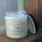 Candle jar with a label on a wooden surface