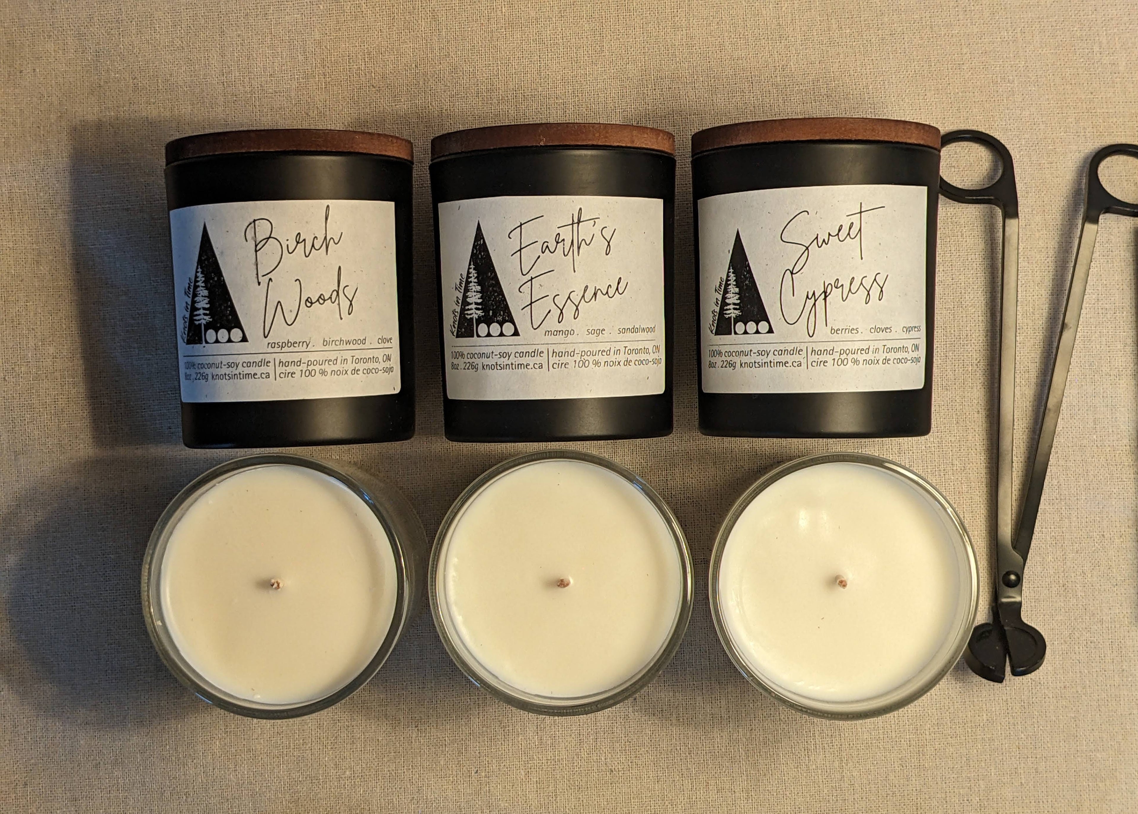 Three candles with labels on a textured surface