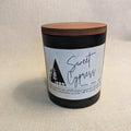 Candle with wooden lid and 'Sweet Cypress' label on a beige background
