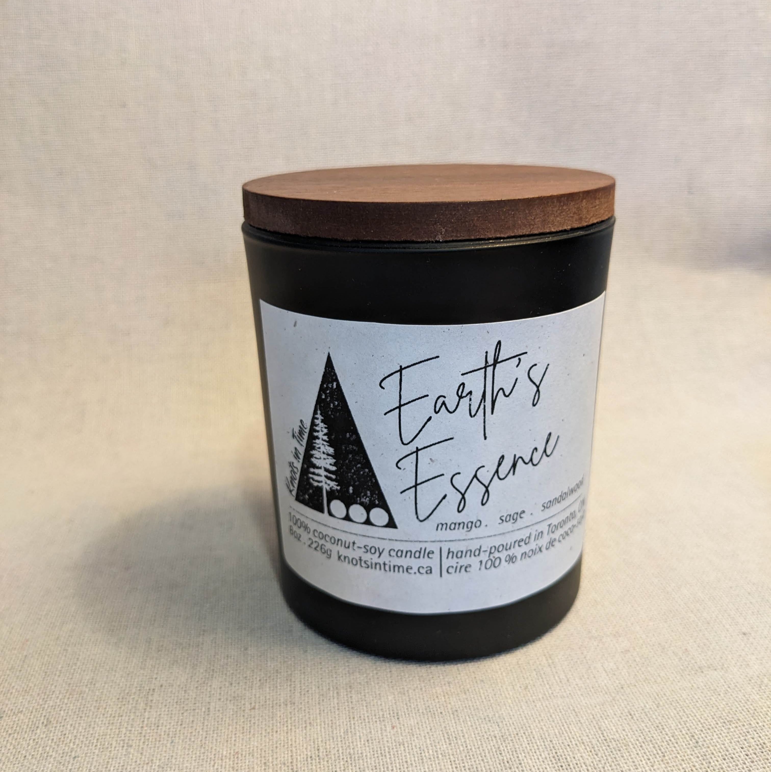 black glass candle with wood lid on a linen texture background