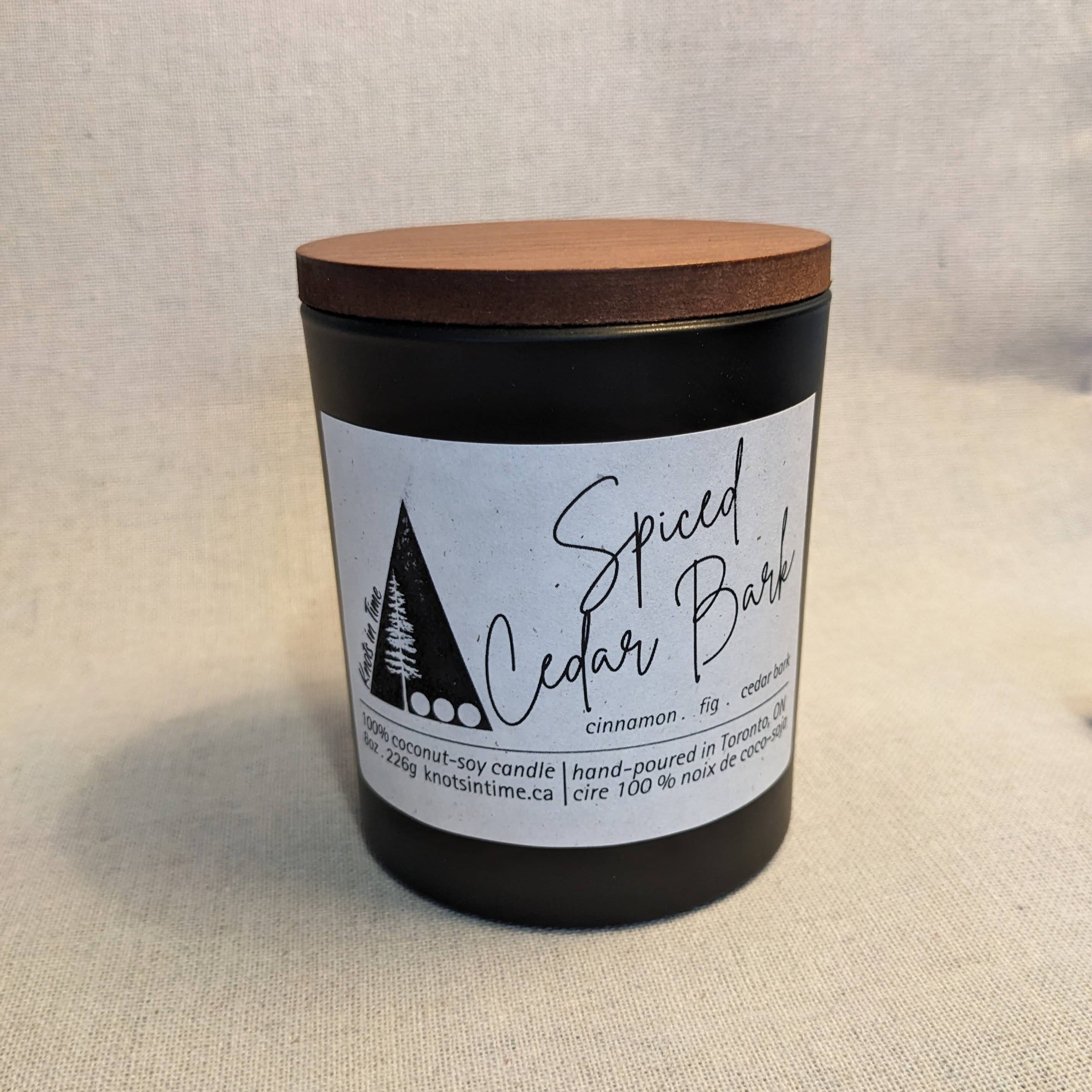 Candle with wooden lid and label on a textured surface