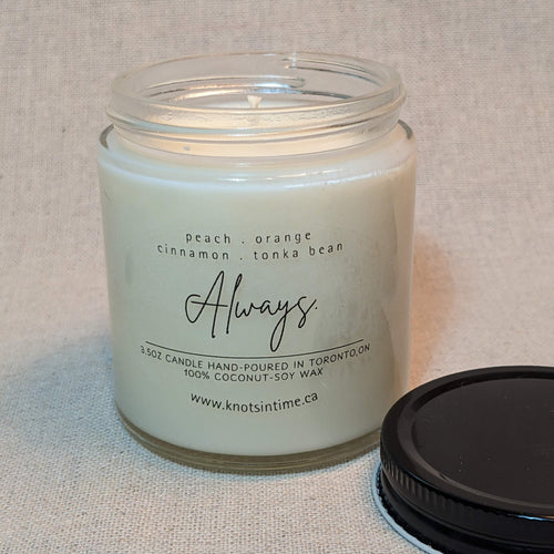 Candle in a glass jar with a label on a textured surface