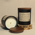 Candle with wooden lid and 'Northern Roots' label on a linen texture background
