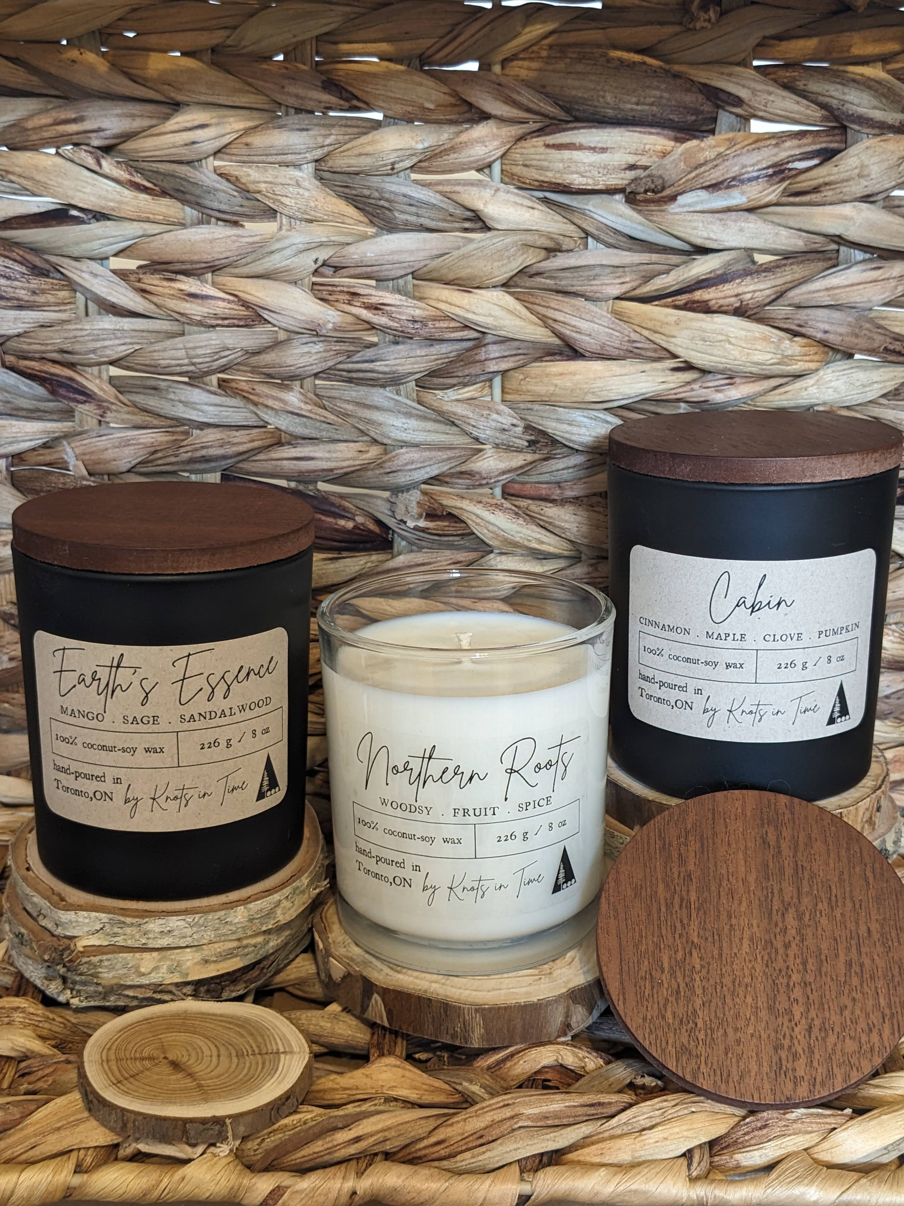 Three candles with labels on a woven surface