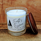 Candle in a glass jar with a wooden lid on a wooden surface, featuring 'Earth's Essence' label.