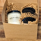 Three candles in a decorative box with woven paper. 