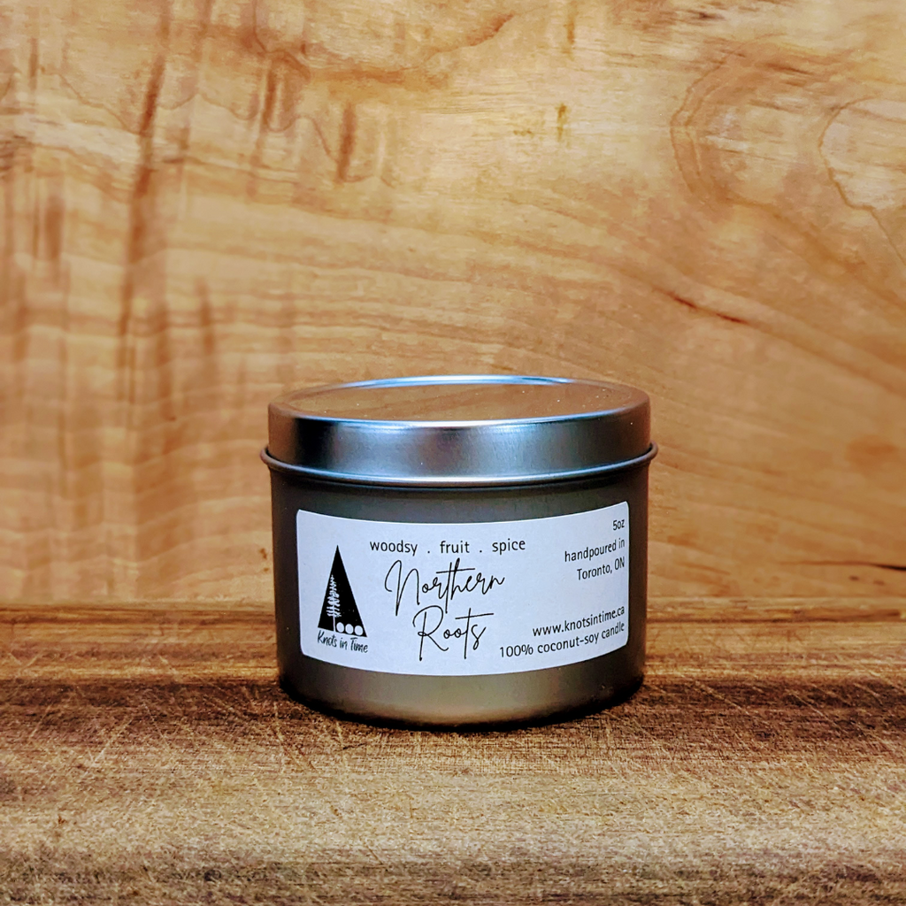 Candle tin with 'Northern Roots' label on a wooden surface