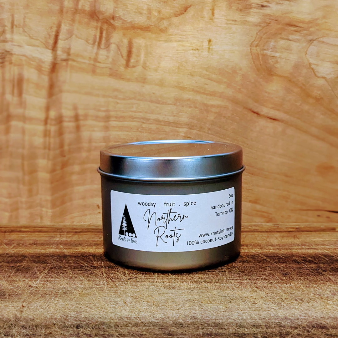 Candle tin with 'Northern Roots' label on a wooden surface