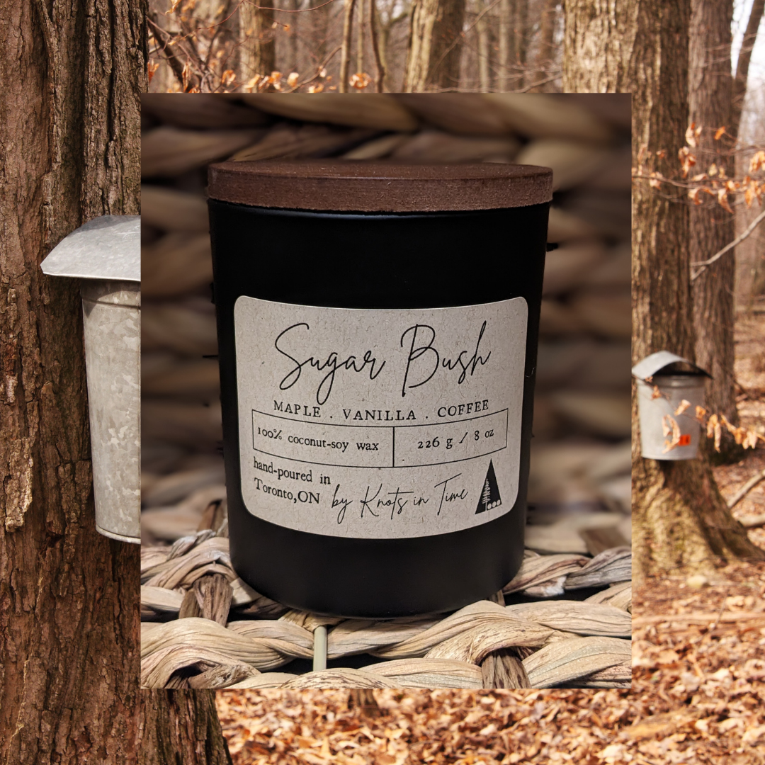 Black candle labeled 'Sugar Bush' with a forest background